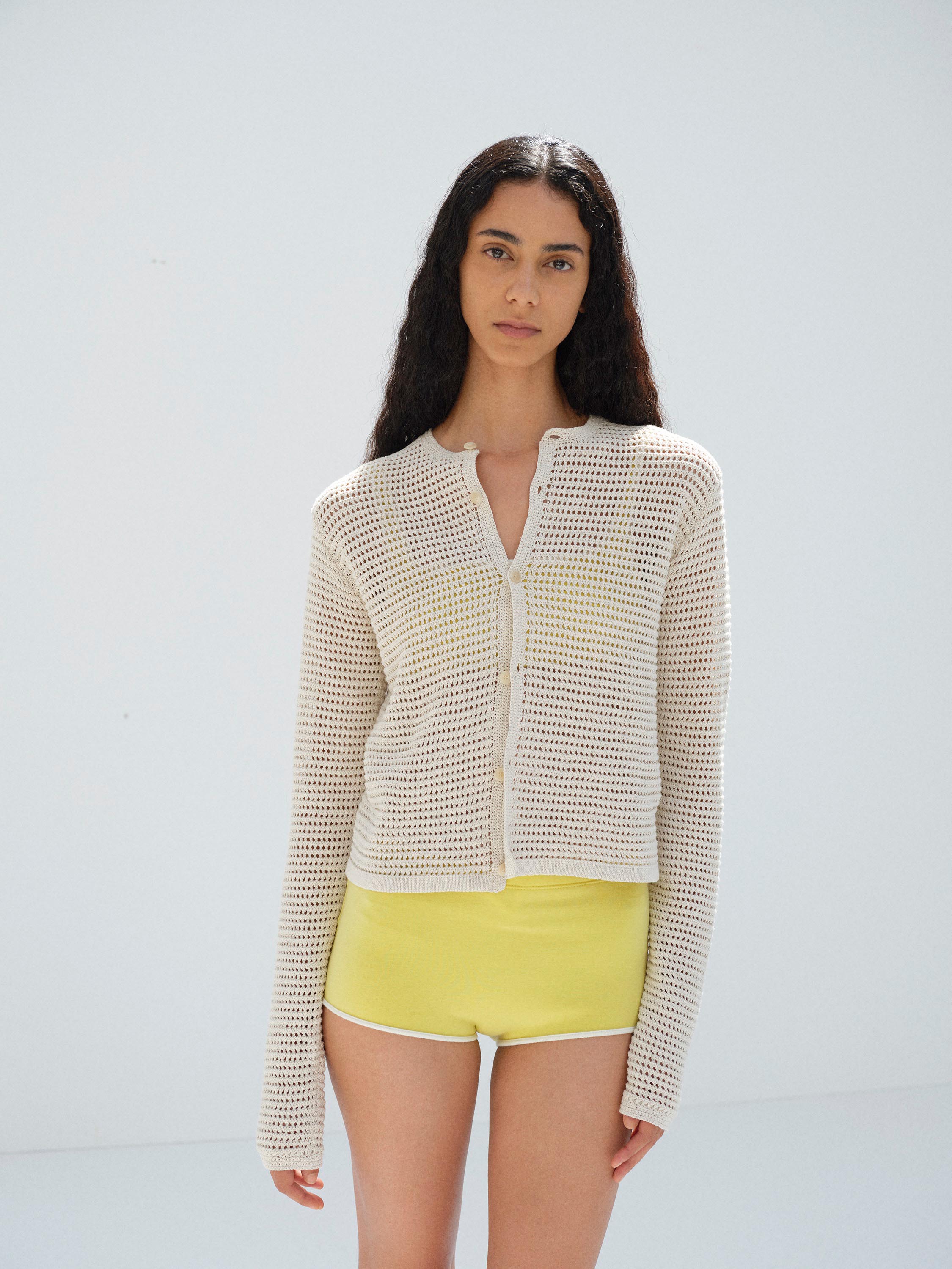 Métisse cheveux longs ondulés · Cardigan maille ajourée crème · Mini-short jaune
